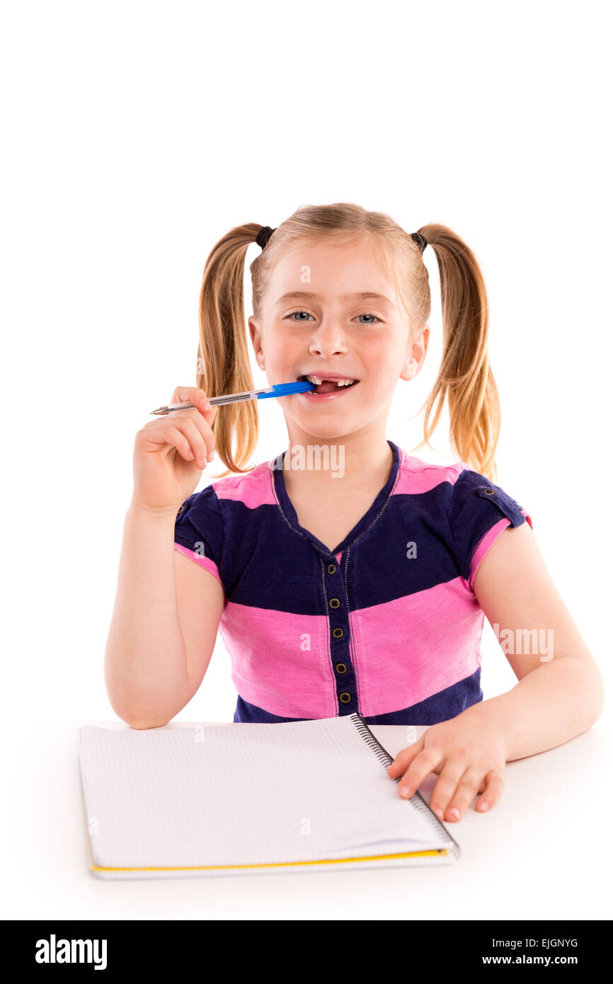 Blonde kid frastagliata una studentessa con notebook a spirale nel banco della pupilla Foto Stock