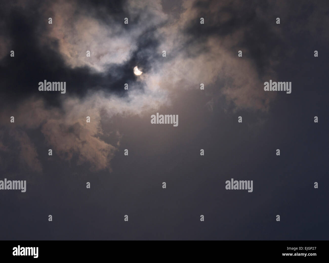 Vista parziale eclissi solare dietro le nuvole Foto Stock