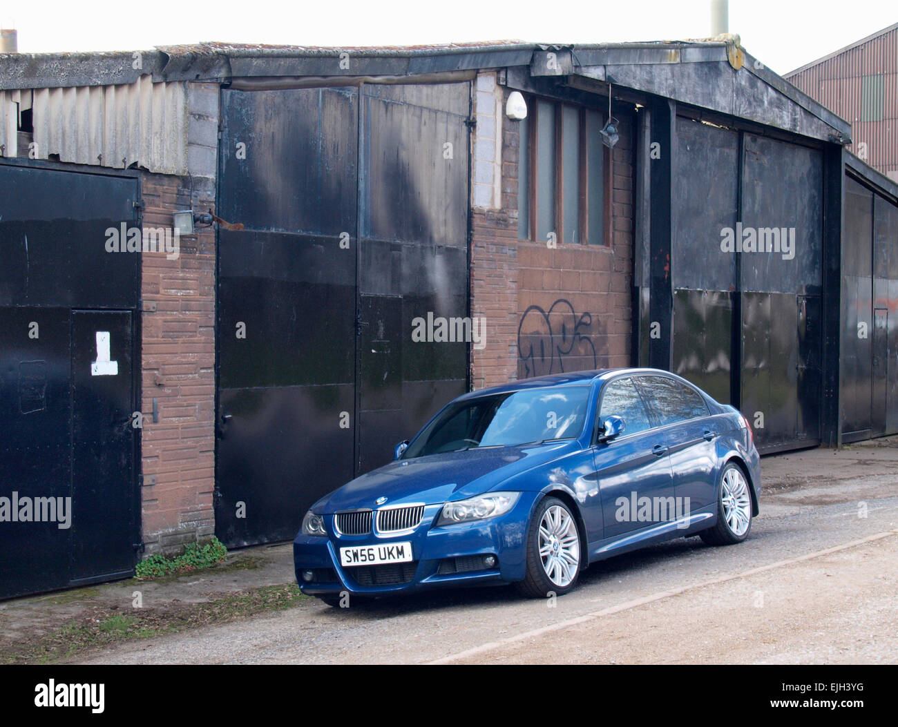 BMW auto parcheggiate accanto al vecchio edificio industriale, Exeter, Devon, Regno Unito Foto Stock