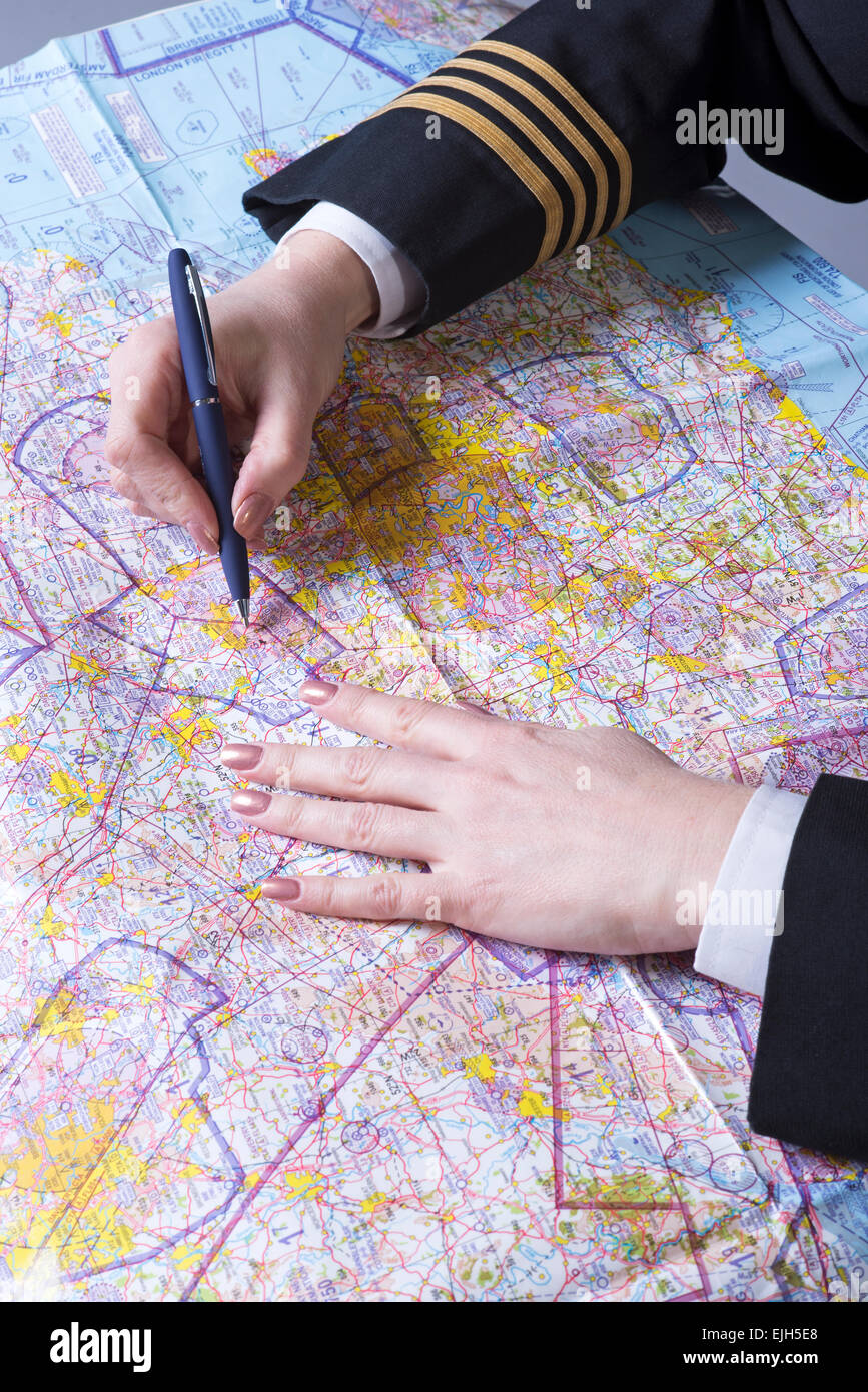 Compagnia aerea ufficiale indossa oro quattro anelli a treccia sul manicotto di pianificare un itinerario Foto Stock