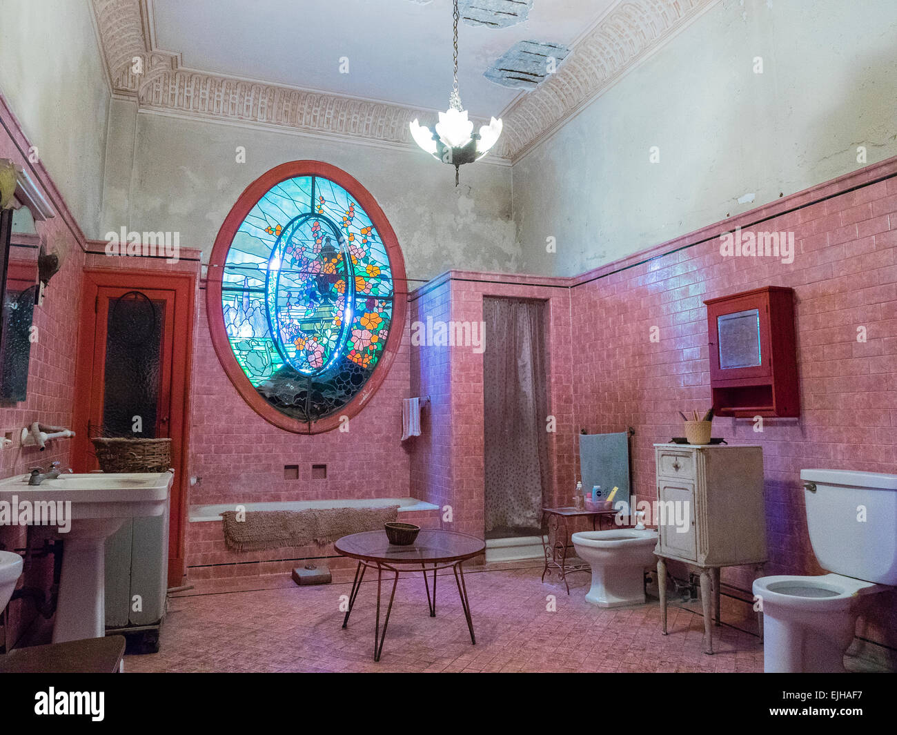 Un grande bagno di pre-rivoluzione mansion cubano con pareti piastrellate, ovale vetrate colorate e i tipici apparecchi sanitari. Foto Stock