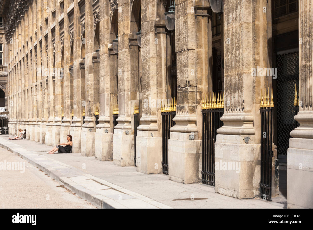Gente seduta sul marciapiede dal Palais Royal, Paris, Francia Foto Stock