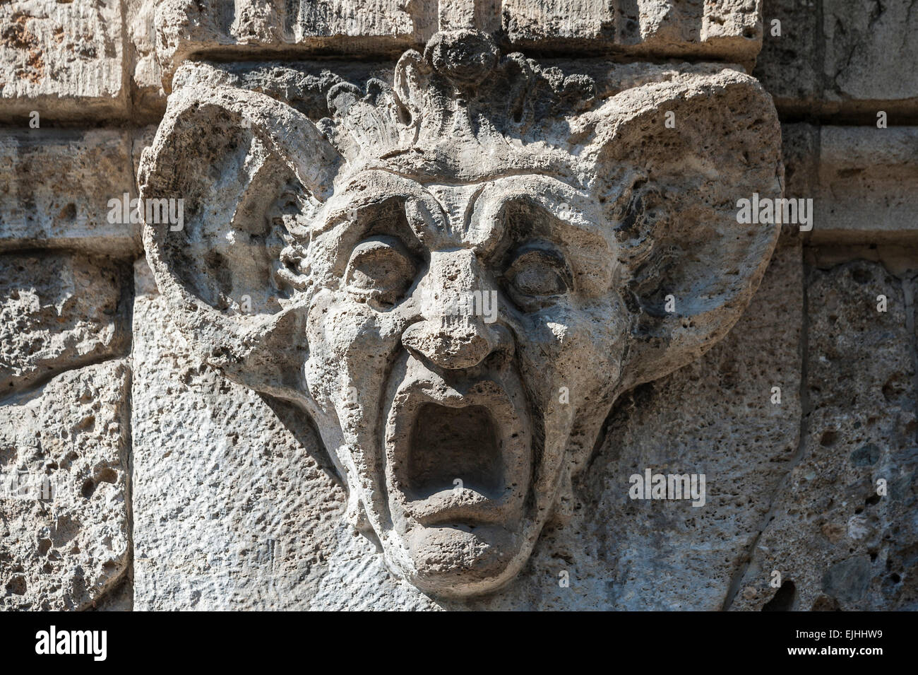 Stone carving, testa con enormi orecchie e bocca spalancata, Monaco di Baviera, Germania Foto Stock