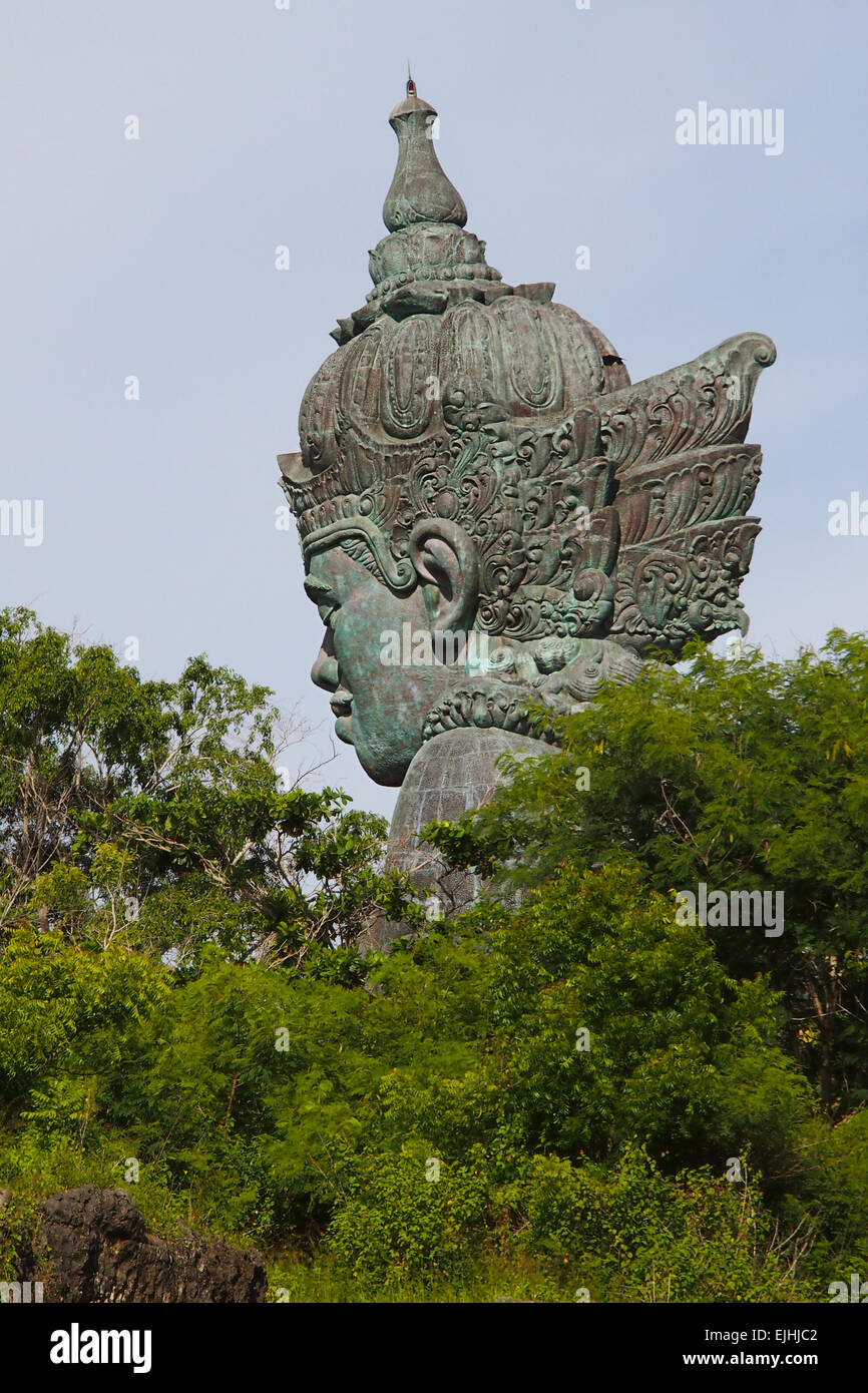 Vista laterale della scultura della testa di Vishnu tra gli alberi Foto Stock