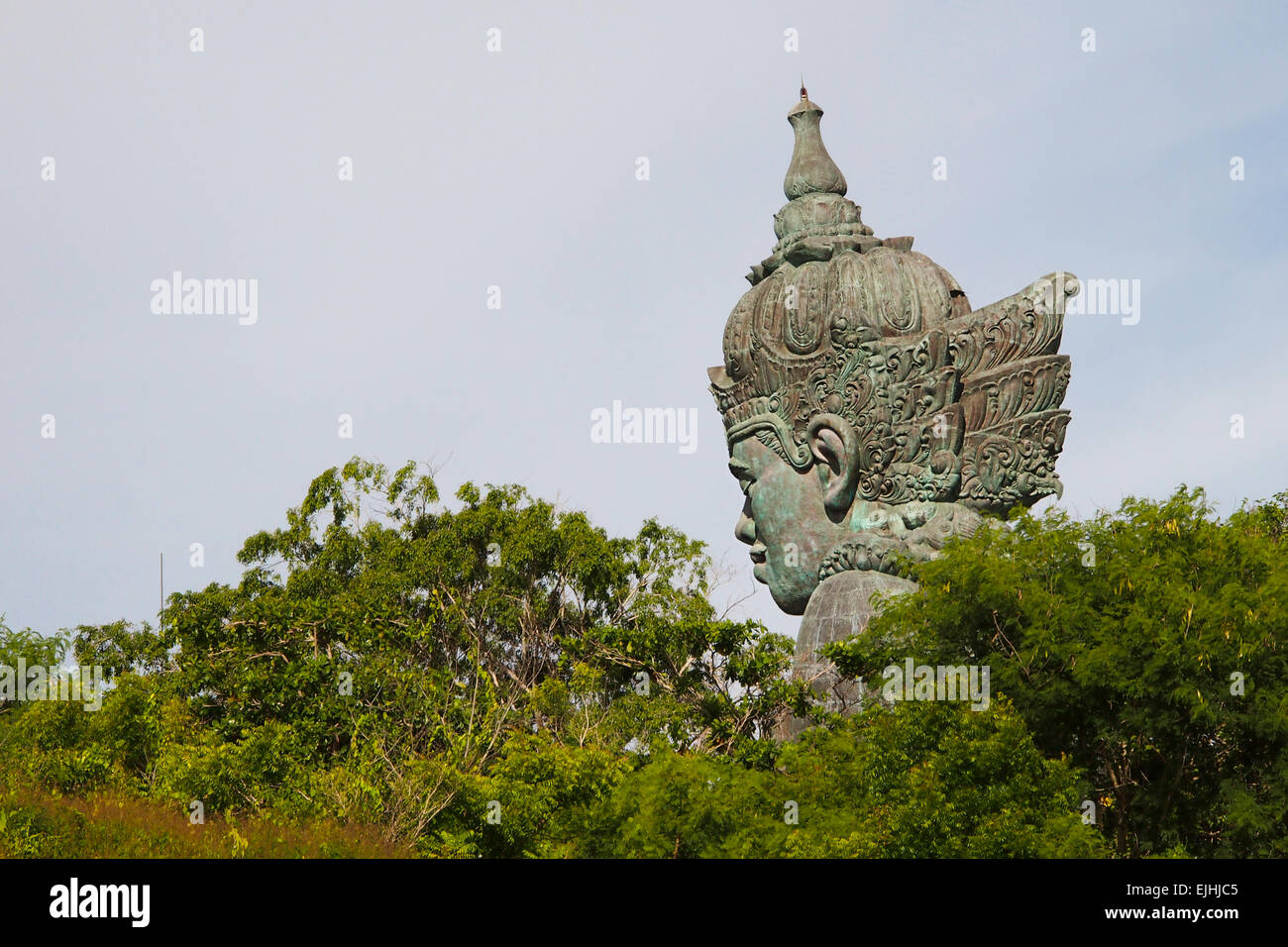 Vista laterale della statua della testa di Vishnu tra gli alberi Foto Stock