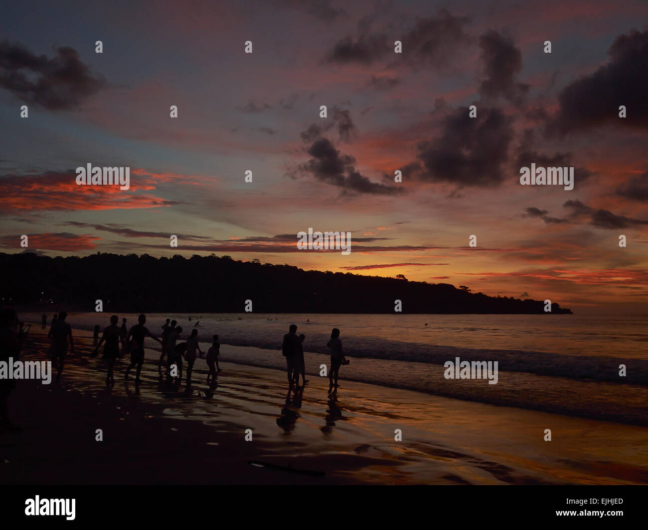 Guarda il tramonto sulla spiaggia di Jimbaran, Bali, Indonesia Foto Stock