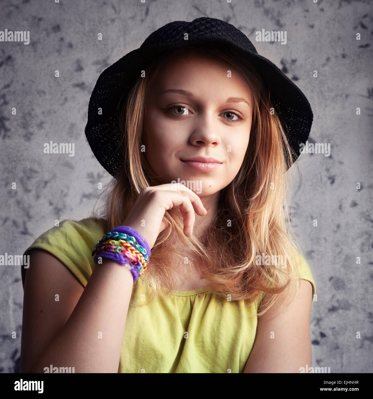 Ritratto di bella bionda ragazza adolescente in black hat e telaio in gomma  braccialetti. Vintage foto dai toni filtro, stile instagram FEP Foto stock  - Alamy