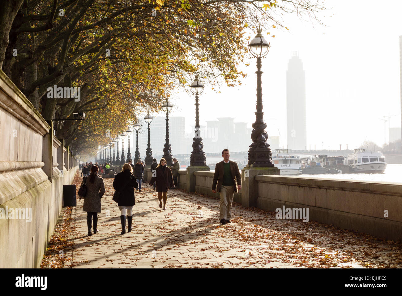 La gente camminare lungo il Fiume Tamigi (Thames Path) vicino a Westminster Bridge, London, Regno Unito Foto Stock