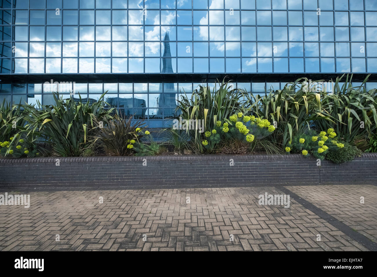 Ufficio con mirroring windows che riflette il cielo blu e nuvole e la Shard, Londra. Foto Stock