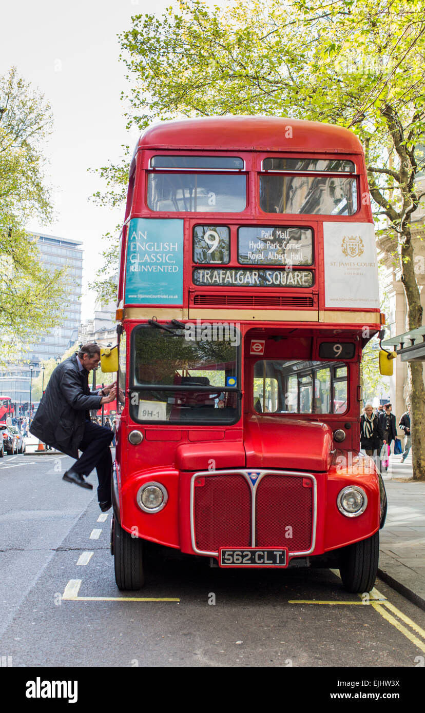 Autista salendo nella sua annata double decker bus di Londra, Londra, Inghilterra Foto Stock