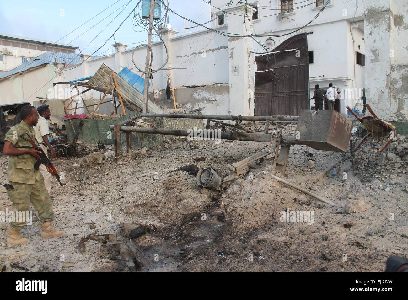 Mogadiscio, Somalia. 27 Mar, 2015. Gli ufficiali di polizia controllare il cancello anteriore di Maka Al-mukarama Hotel dopo un'esplosione a Mogadiscio, capitale della Somalia, il 27 marzo 2015. Almeno cinque persone sono state uccise e decine di feriti in un attentato auto esplosione nella capitale somala Mogadiscio Venerdì, le autorità di polizia hanno confermato. Credito: Abdirahman Hussien/Xinhua/Alamy Live News Foto Stock