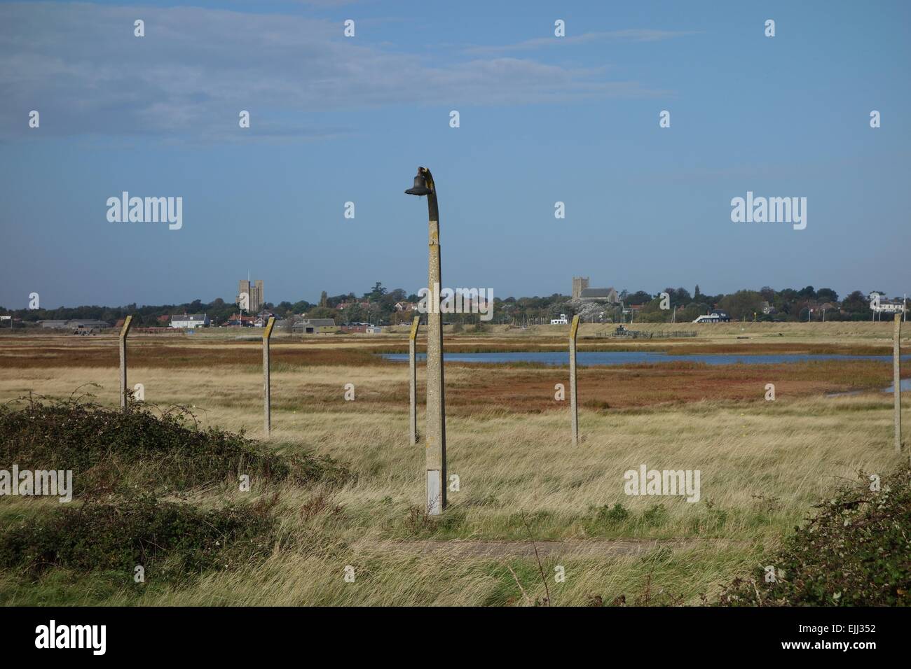 Orford Ness, Suffolk paesaggio palustre visto attraverso MoD era la scherma con pali di calcestruzzo e il filo a Orford CASTELLO E CHIESA Foto Stock