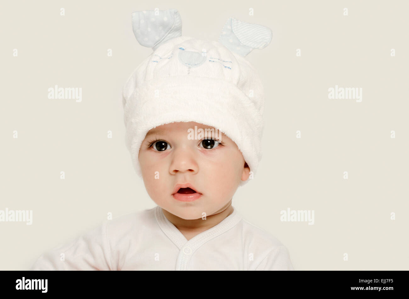 Bambino innocente che indossa un cappello bianco cercando adorabile. Kid  vestita per l'inverno, grazioso neonato. Adorable baby ritratto alla  ricerca di curiosita' Foto stock - Alamy