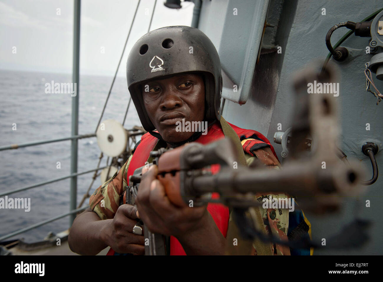 Un Beninese naval imbarco soldato team fornisce la sicurezza di una simulazione di contrabbando di droga scenario come parte di Obangame Express a bordo della marina tedesca nave FGS Brandeburgo Marzo 25, 2015 in tema, Ghana. Foto Stock