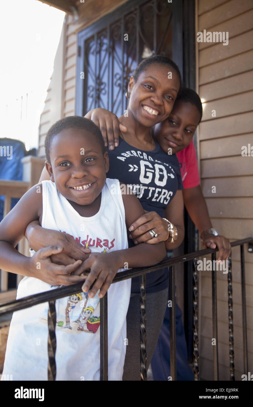 Ritratto di madre e due figli sulla loro veranda sul retro di Brooklyn, New York. Foto Stock