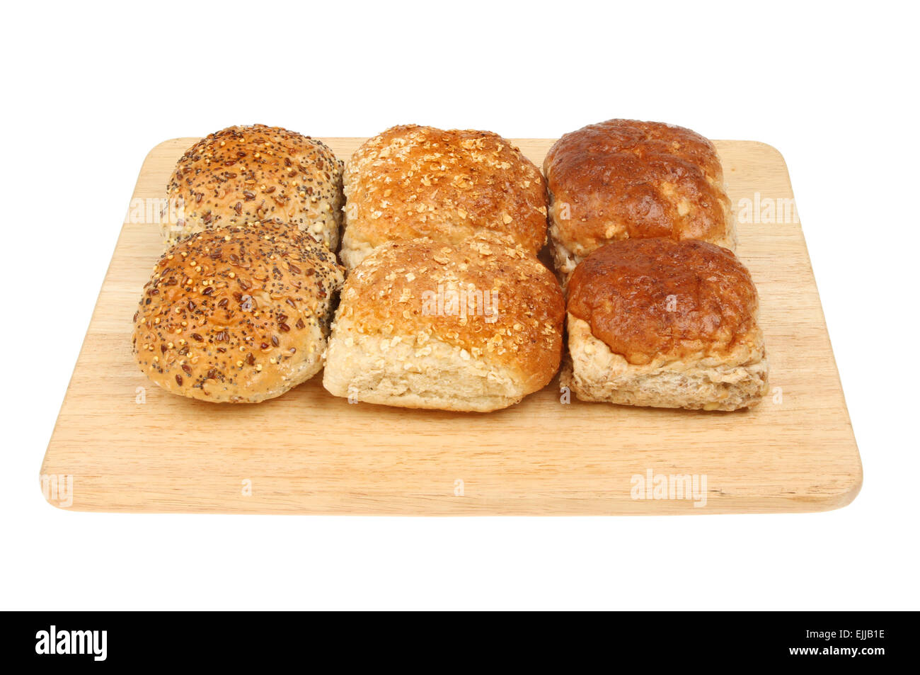 Pane misto rotola su una tavola di legno isolata contro bianco Foto Stock