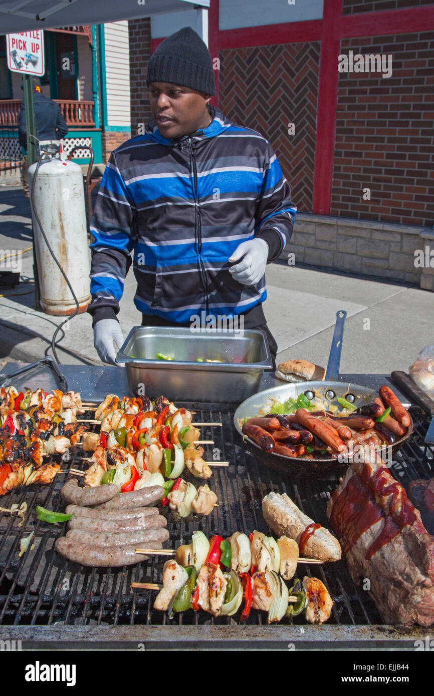 Detroit, Michigan - un lavoratore tende cibo alla griglia al di fuori di Mario's Restaurant. Foto Stock