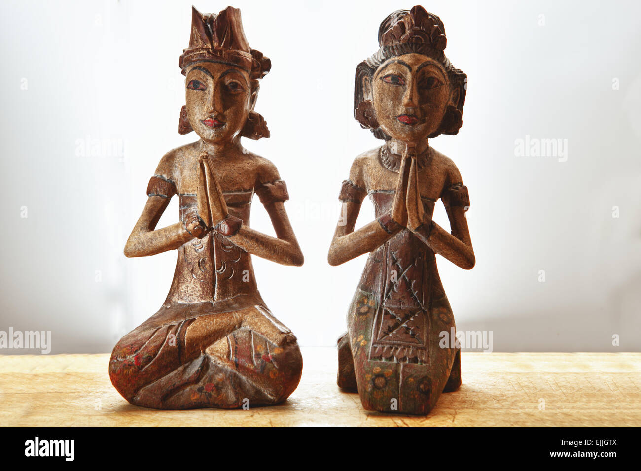 Thailandia souvenir in legno giovane nella tradizionale preghiera e ringraziamento pongono. Isolato su sfondo bianco, posto sul trattamento di legno Foto Stock