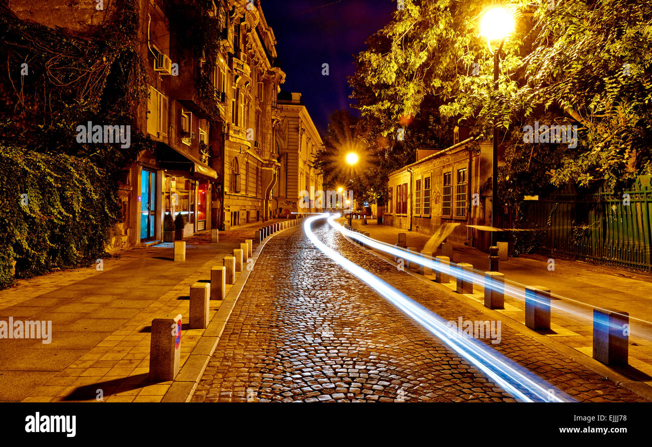 Luci auto sul vecchio, pavimentato strada della citta'. Foto Stock
