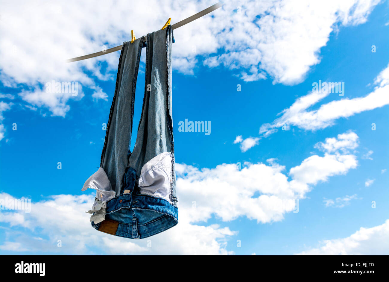 Jeans blu appesi per asciugare in cielo. Foto Stock