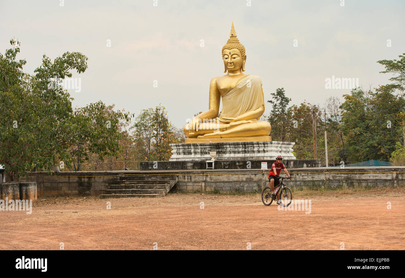 Ciclista e il Buddha nelle zone rurali della Thailandia Foto Stock