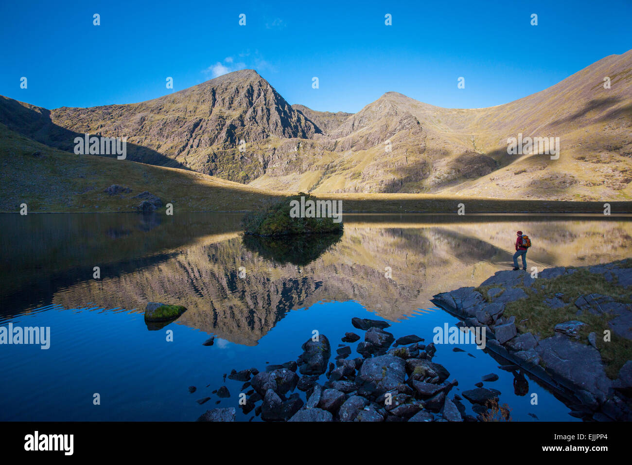 Escursionista accanto a Lough chiamato, sotto Carrauntoohil Beenkeragh e. Hag's Glen, del MacGillycuddy Reeks, nella contea di Kerry, Irlanda. Foto Stock