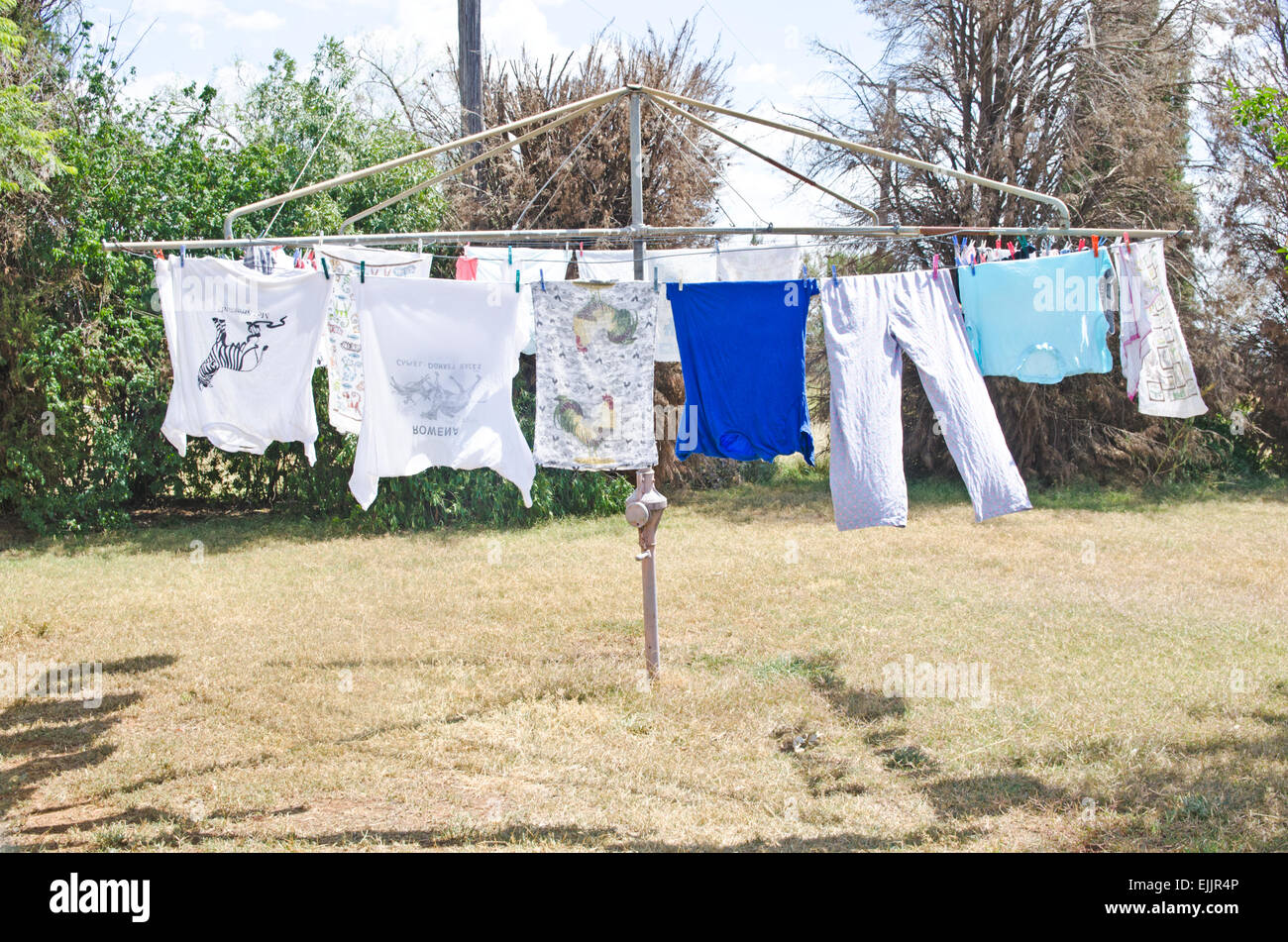 Il lavaggio appesi a un rotary linea di abbigliamento in una giornata di sole Foto Stock