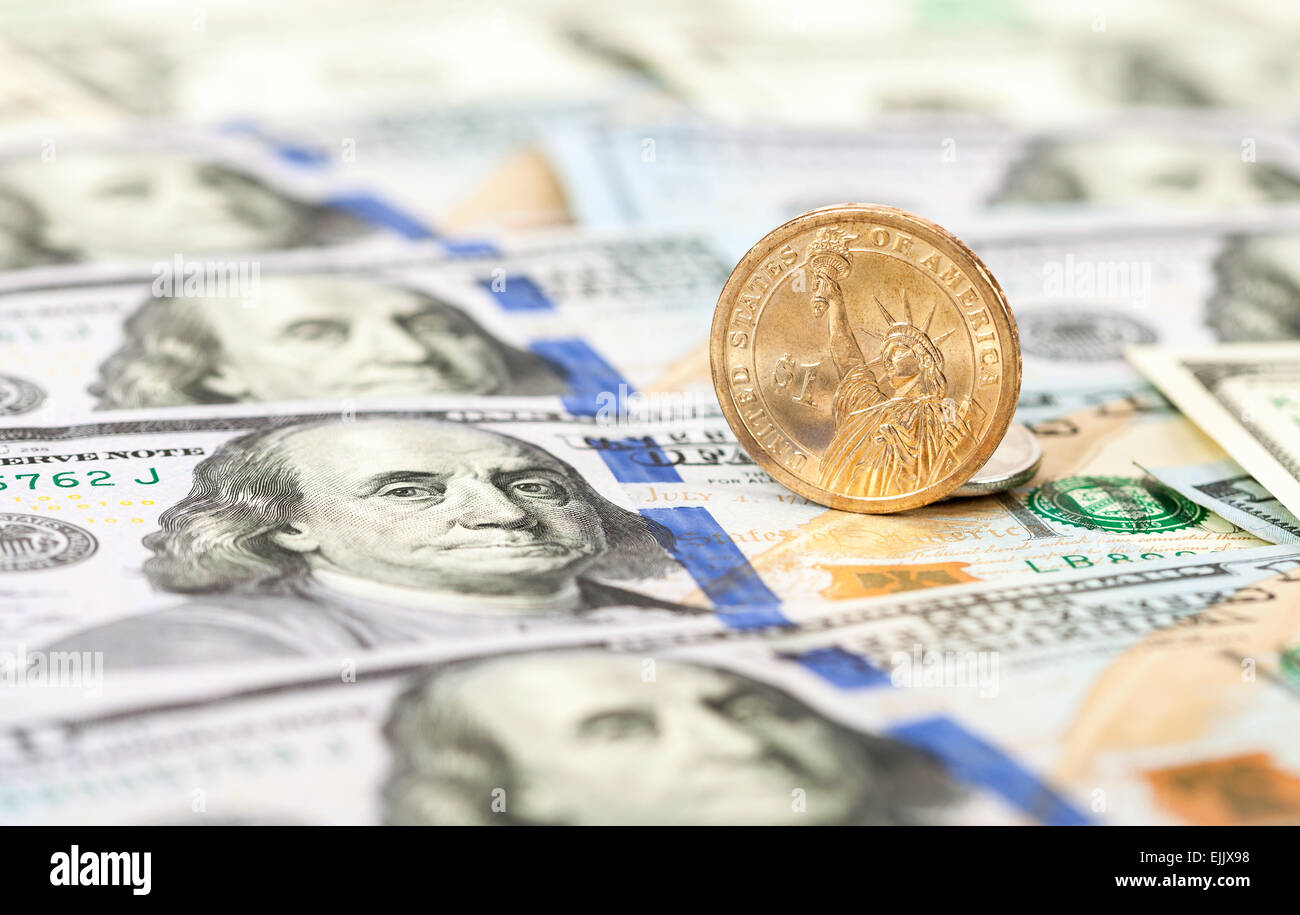 Un dollaro americano medaglia giacente sulla parte superiore delle banconote da cento dollari close up Foto Stock