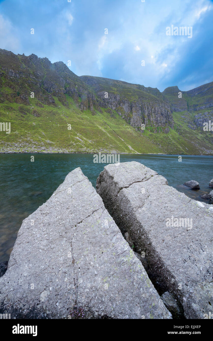 Split rock sulla riva del Coumshingaun Lough, Comeragh montagne, nella contea di Waterford, Irlanda. Foto Stock