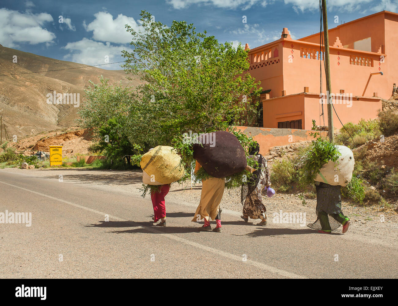 Donne arabe portano pesanti sacchi sul loro retro in Marocco Foto Stock
