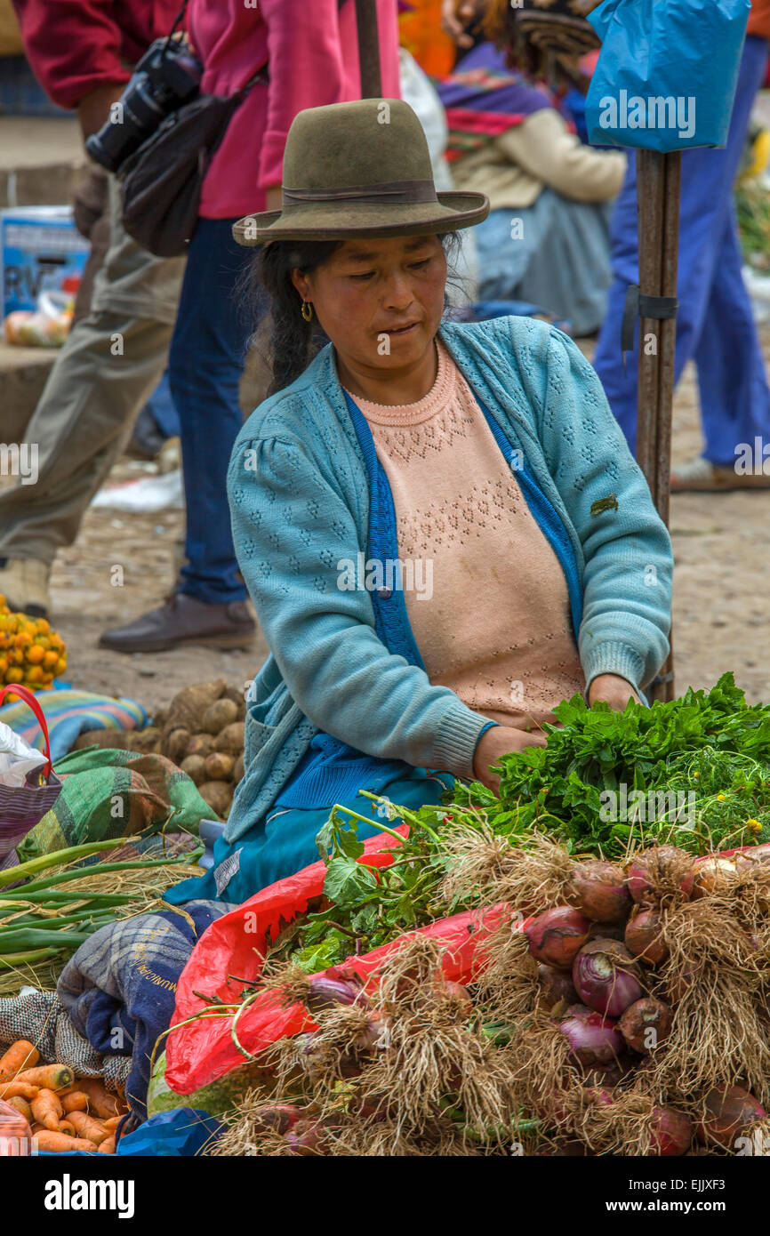 Il quechua donna vende ortaggi in un mercato di Pisac, Perù Foto Stock