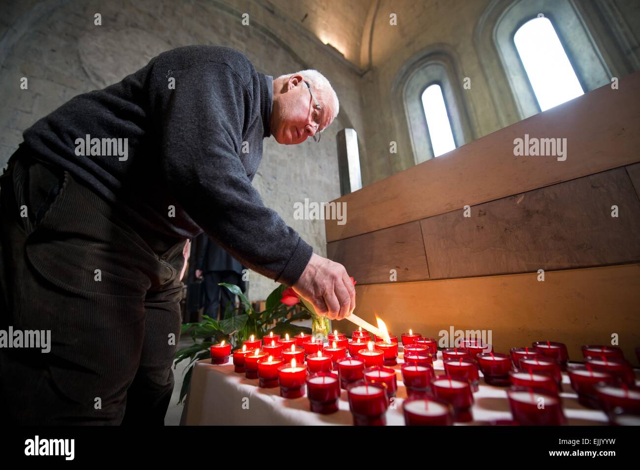 Ein Mitglied der Kirchengemeinde zündet 150 Kerzen am 28.03.2015 in Digne-Les-Bains, Frankreich, in der katholischen Kathedrale Notre Dame du Bourg vor einem Gedenkgottesdienst in Gedenken an die Opfer des Germanwings A320 Absturz un. Foto: Daniel Naupold/dpa (c) dpa - Bildfunk Foto Stock