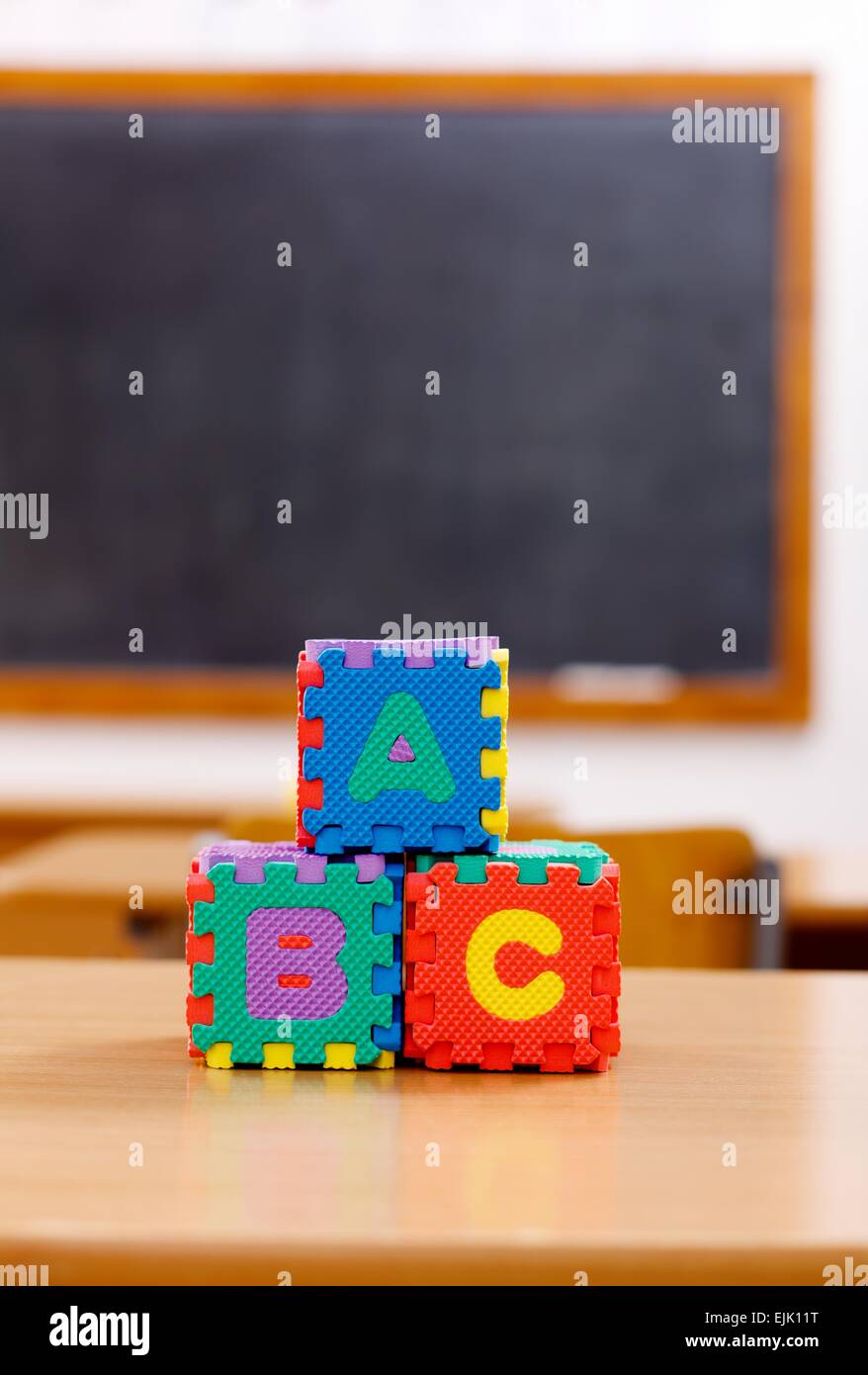 Lettera di ABC puzzle blocchi sul tavolo in aula vuota Foto Stock