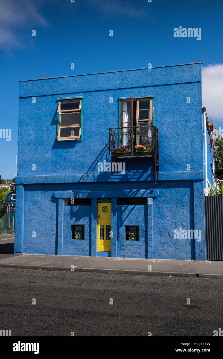 Blue Square in cemento costruiti casa unifamiliare con sportello giallo e piccolo balcone sulla periferia di Napier, Nuova Zelanda. Foto Stock