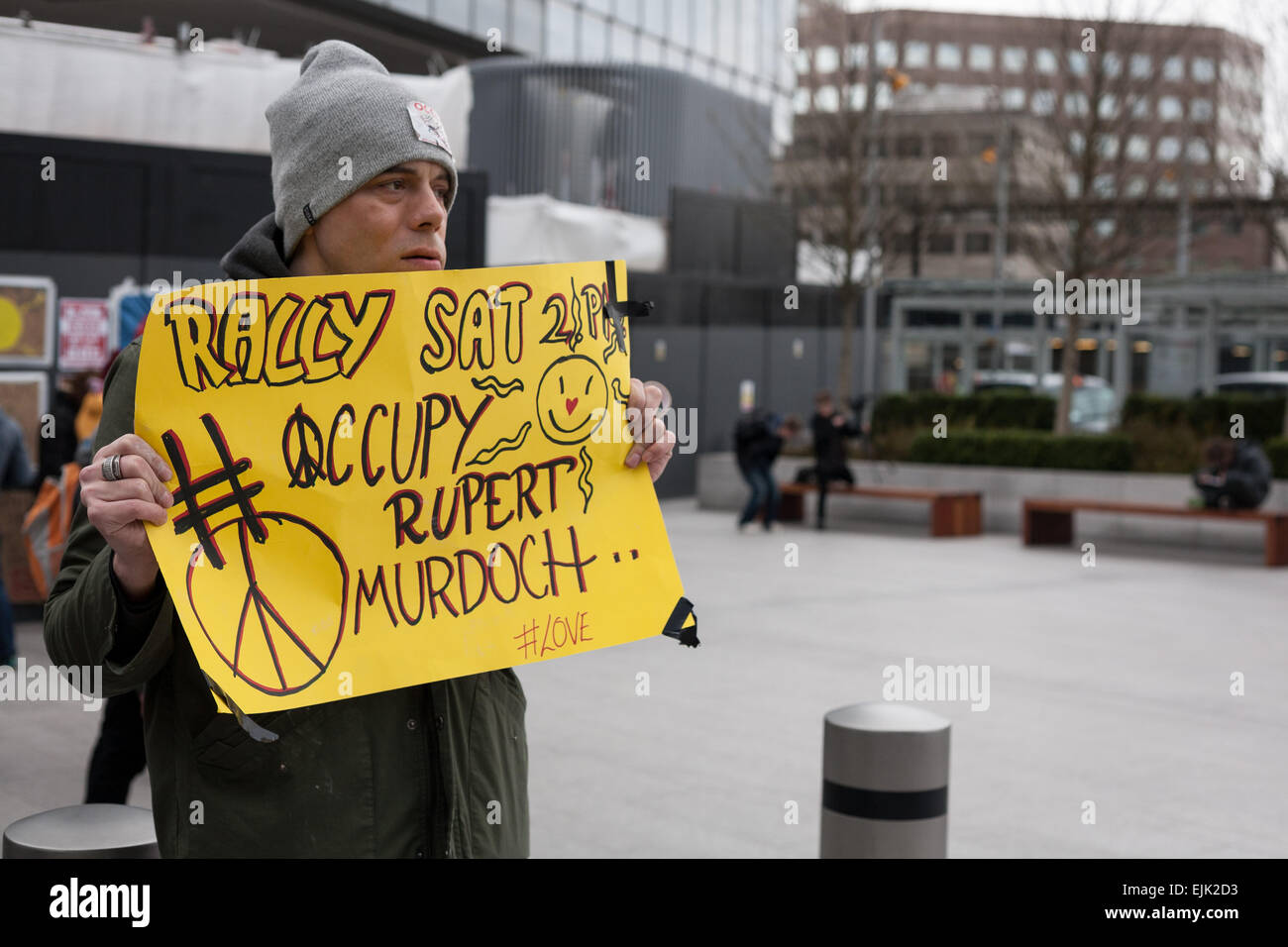 Londra, Regno Unito. 28 marzo, 2015. Un dimostrante detiene una targhetta durante il sesto giorno di 'occupano Rupert Murdoch" protesta al di fuori della sede della News UK a Londra. La settimana di protesta, dovuti alla fine domenica 29 marzo, è stata organizzata dalla "Occupare' movimento attivista per evidenziare la elevata percentuale totale di media britannici di proprietà di Rupert Murdoch (testa di notizie britannico della capogruppo News Corp) e quattro altri diritto-miliardario pendente di imprenditori. Credito: David Cliff/Alamy Live News Foto Stock