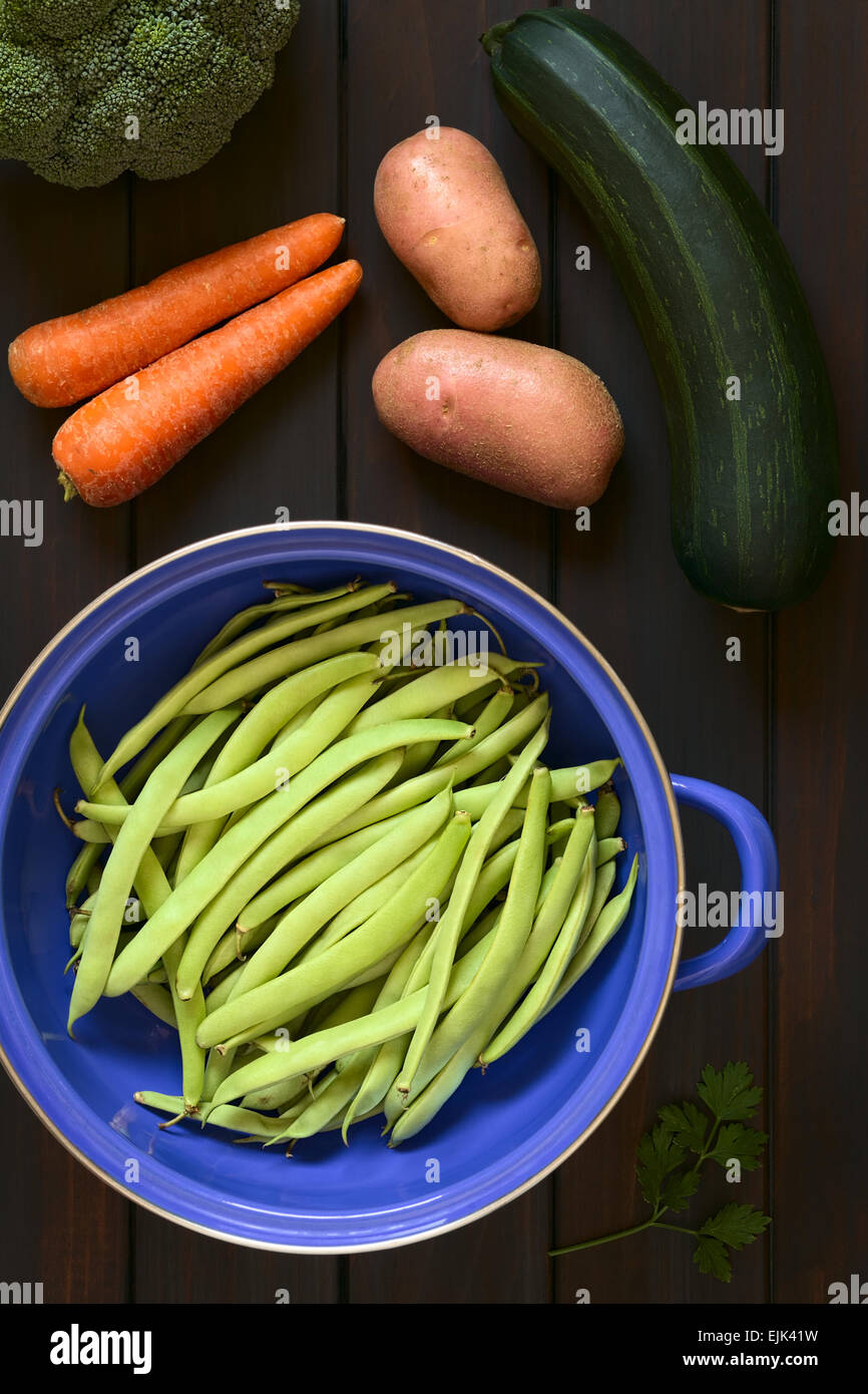 Tettuccio di colpo di fagioli verdi in blu il filtro di metallo con prezzemolo, broccoli, carota, patata e zucchine Foto Stock