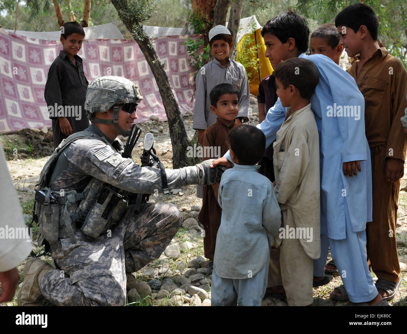 Stati Uniti Esercito Cpl. Joshua A. Poindexter, di San Diego, California, leader di un team con la seconda squadra, primo plotone, conti nella 630 a Polizia Militare Company, Task Force Spartan, scuote le mani con i giovani abitanti di un villaggio dopo aver aiutato passare fuori donato forniture scolastiche nel quartiere Beshood dell Afghanistan orientale della provincia di Nangarhar, e il agosto 14. La manifestazione è stata coordinata dal personale Sgt. Nicole Olcott, di Daytona Beach, Florida, a missioni di volo planner con sede e sede di truppe, 3° Stormo, diciassettesimo reggimento di cavalleria, Task Force Lighthorse. Le due scatole di forniture scolastiche è venuto da Matthew Freeman Foundation, l'annuncio Foto Stock