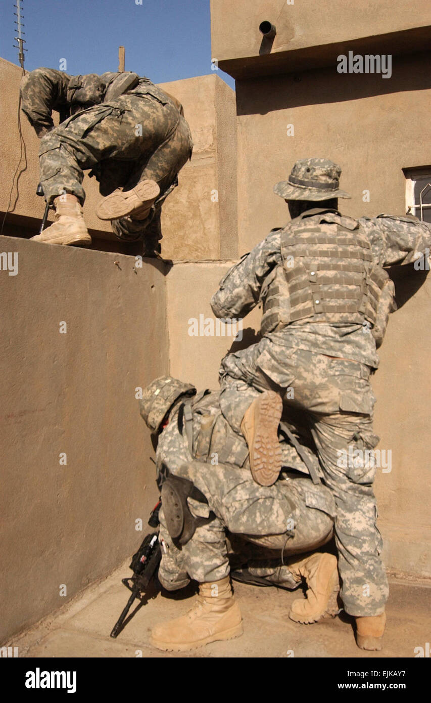 Stati Uniti I soldati dell esercito manovra sui tetti durante una battaglia di pistola in Al Doura, Baghdad, Iraq, Marzo 5, 2007. I soldati sono da Bravo Company, 2° Battaglione, dodicesimo Reggimento di Fanteria, 2° Brigata Team di combattimento, seconda divisione di fanteria. Spc. Olanrewaju Akinwunmi Foto Stock