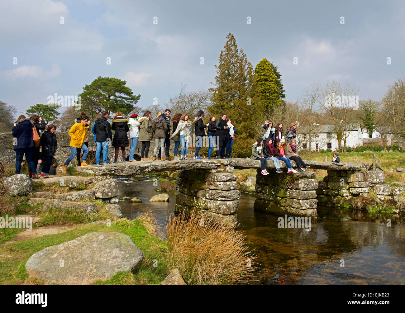 Un sacco di persone affollano sul vecchio clapper bridge, a Postbridge, Parco Nazionale di Dartmoor, Devon, Inghilterra, Regno Unito Foto Stock