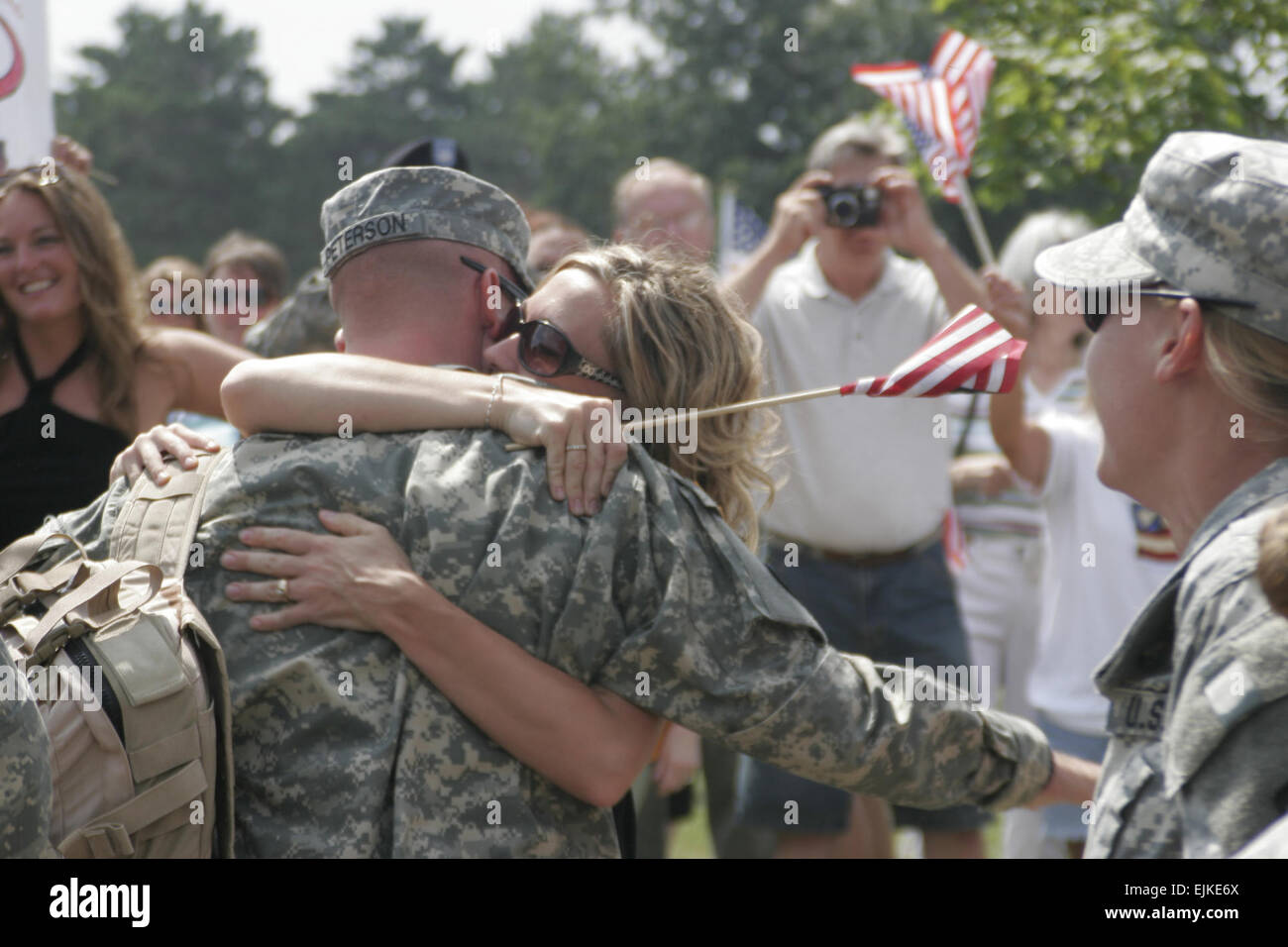 Stati Uniti Army Sgt. Mike Peterson riceve baci e abbracci da sua moglie per la prima volta dal suo arrivo a casa dall'Iraq a Brooklyn Park Armory in Minnesota Luglio 17, 2007. Peterson è un soldato con Alfa Company, 134Brigata Battaglione di supporto, chi è stato in Iraq con il 1 ° brigata Team di combattimento, 34a divisione di fanteria. Sgt. Kenneth Toole Foto Stock