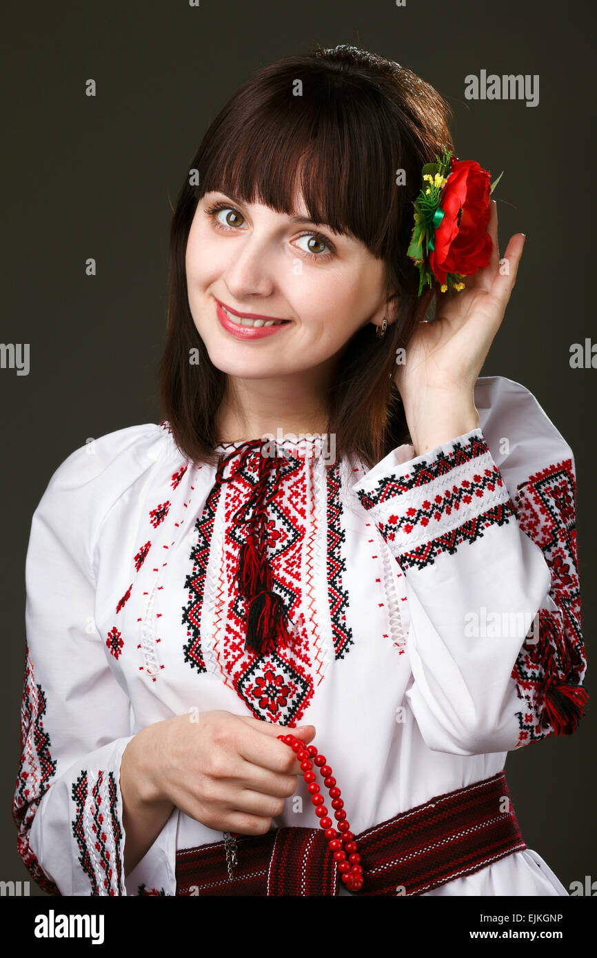 Bella donna in una camicia ricamata con fiore nei capelli Foto Stock