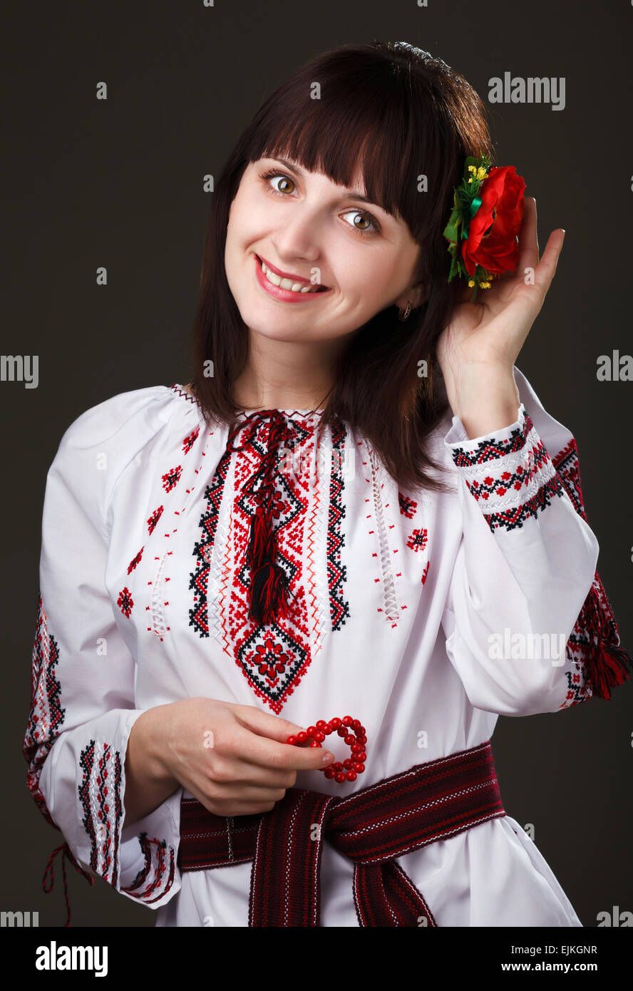 Donna affascinante in una camicia ricamata con fiore nei capelli Foto Stock