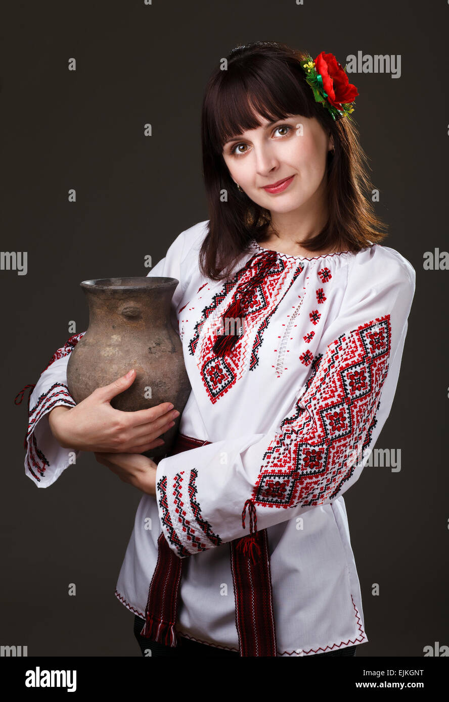 Bella donna in una camicia ricamata con una brocca nelle sue mani Foto Stock