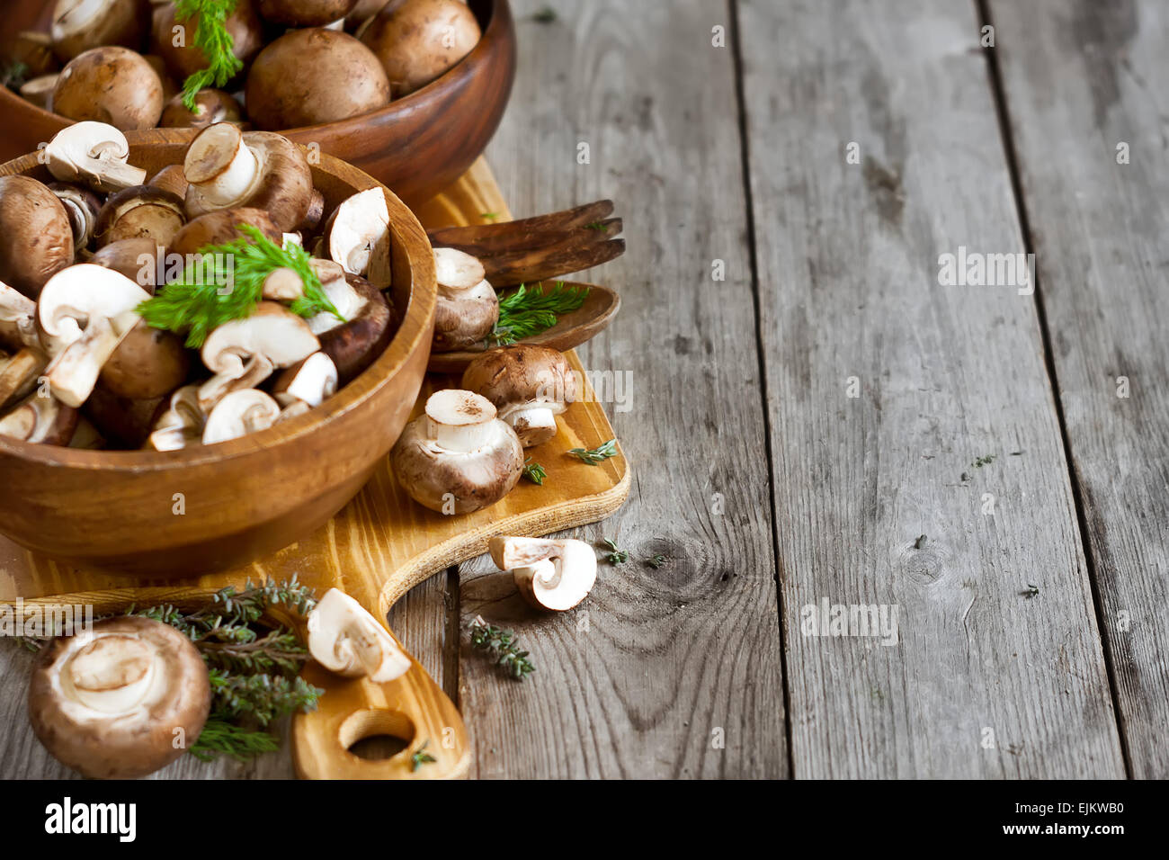 Crudo fresco funghi portabello con coltello in ciotole di legno su uno sfondo di legno vecchio Foto Stock