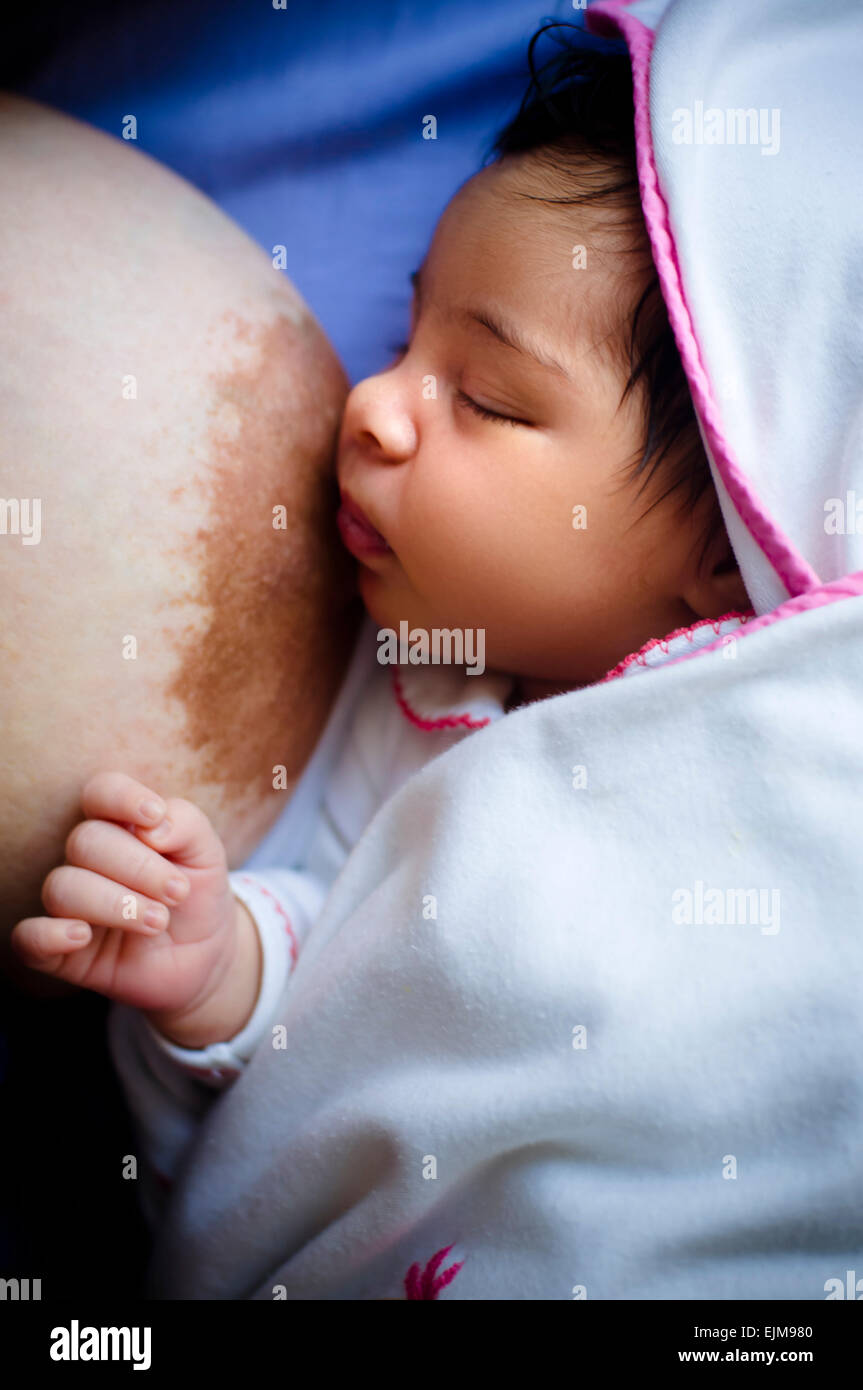 Sleeping Baby girl neonato accanto alla madre dopo essere stati allattati al seno Foto Stock