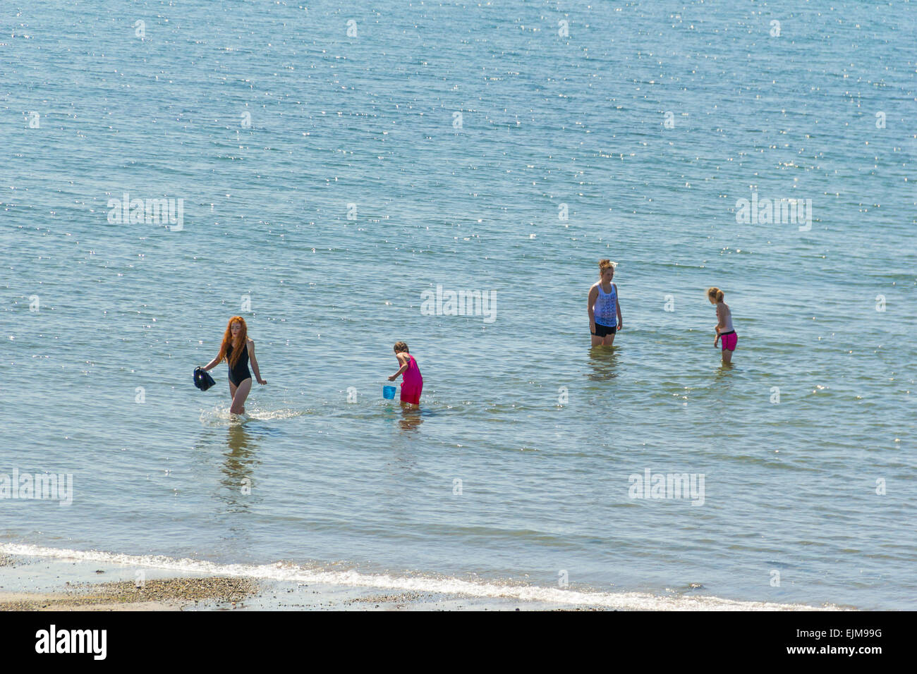 I bambini a fare il bagno in un mare, Cardigan Bay, a Criccieth, il Galles del Nord, Regno Unito. Foto Stock