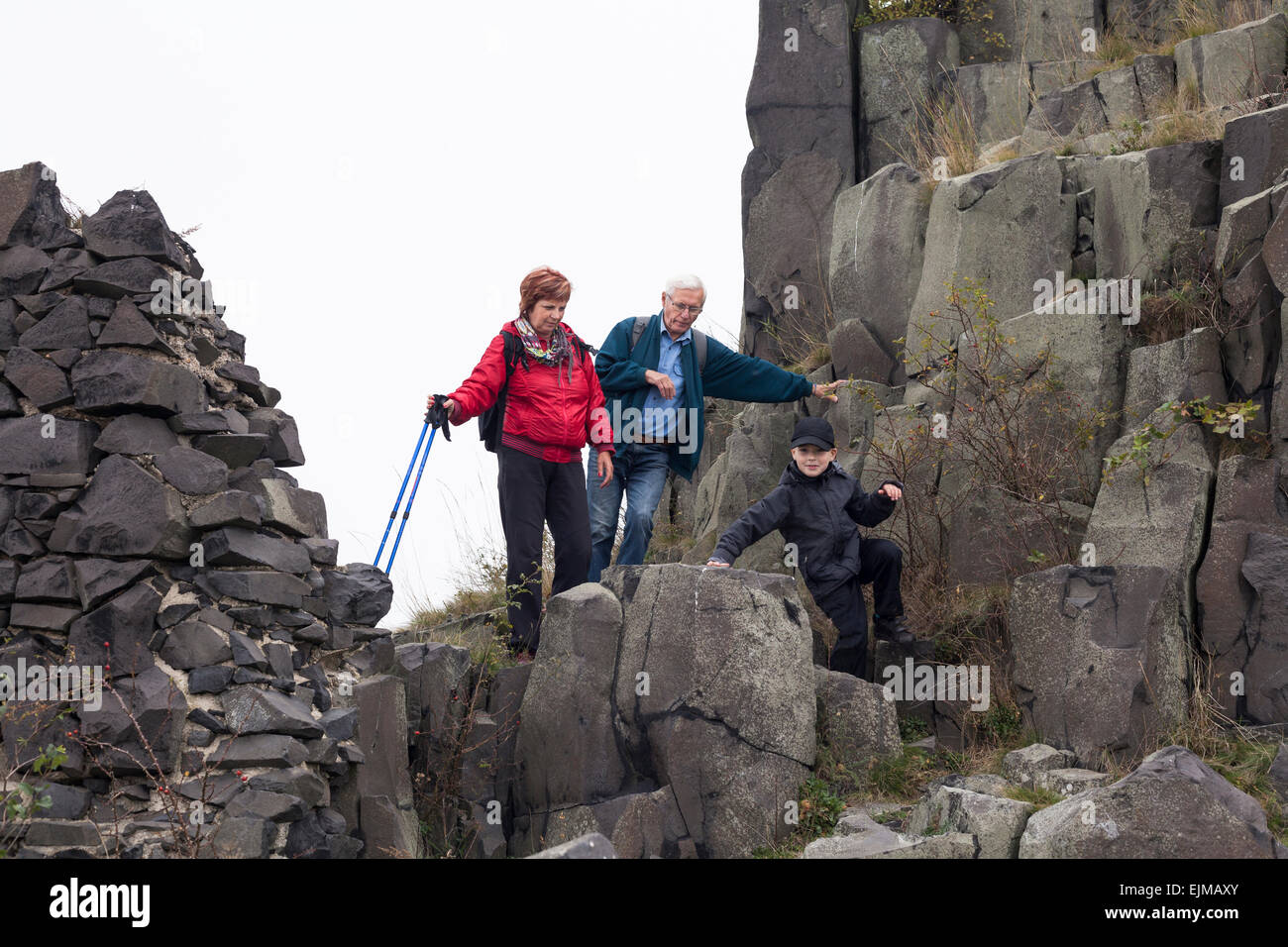 Coppia senior e bambino ragazzo trekking sul terreno roccioso. Foto Stock