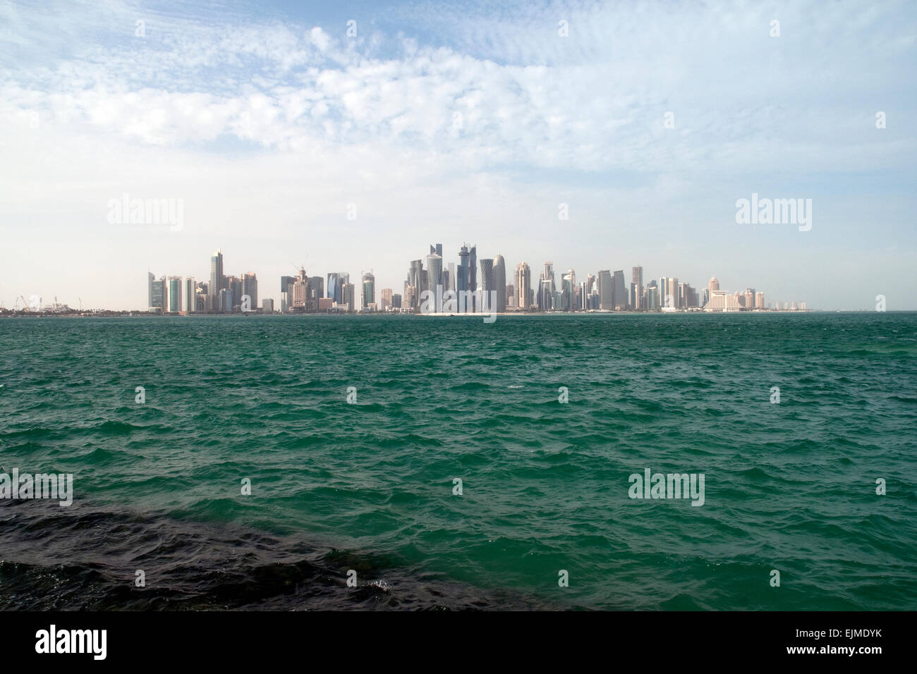 Lo skyline di Doha, Qatar e le acque del Golfo Arabico. Foto Stock