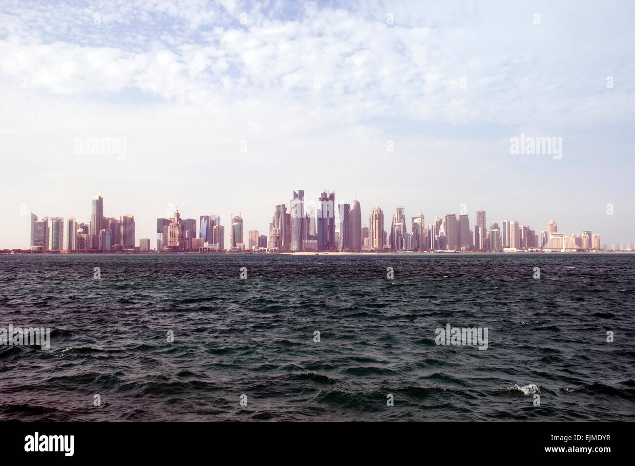 Lo skyline di Doha, Qatar e le acque del Golfo Arabico. Foto Stock