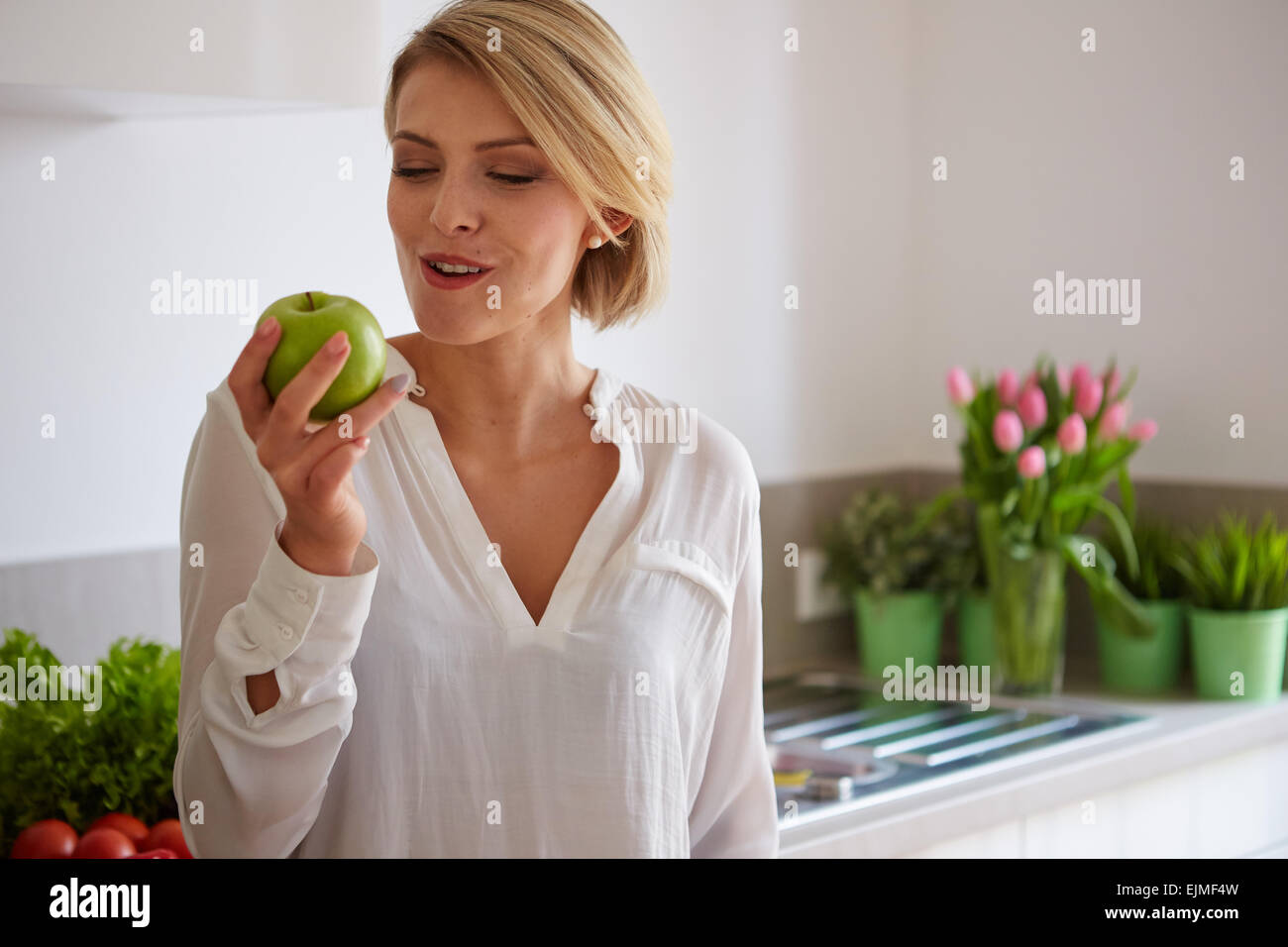 Felice giovane donna di mangiare le mele Foto Stock